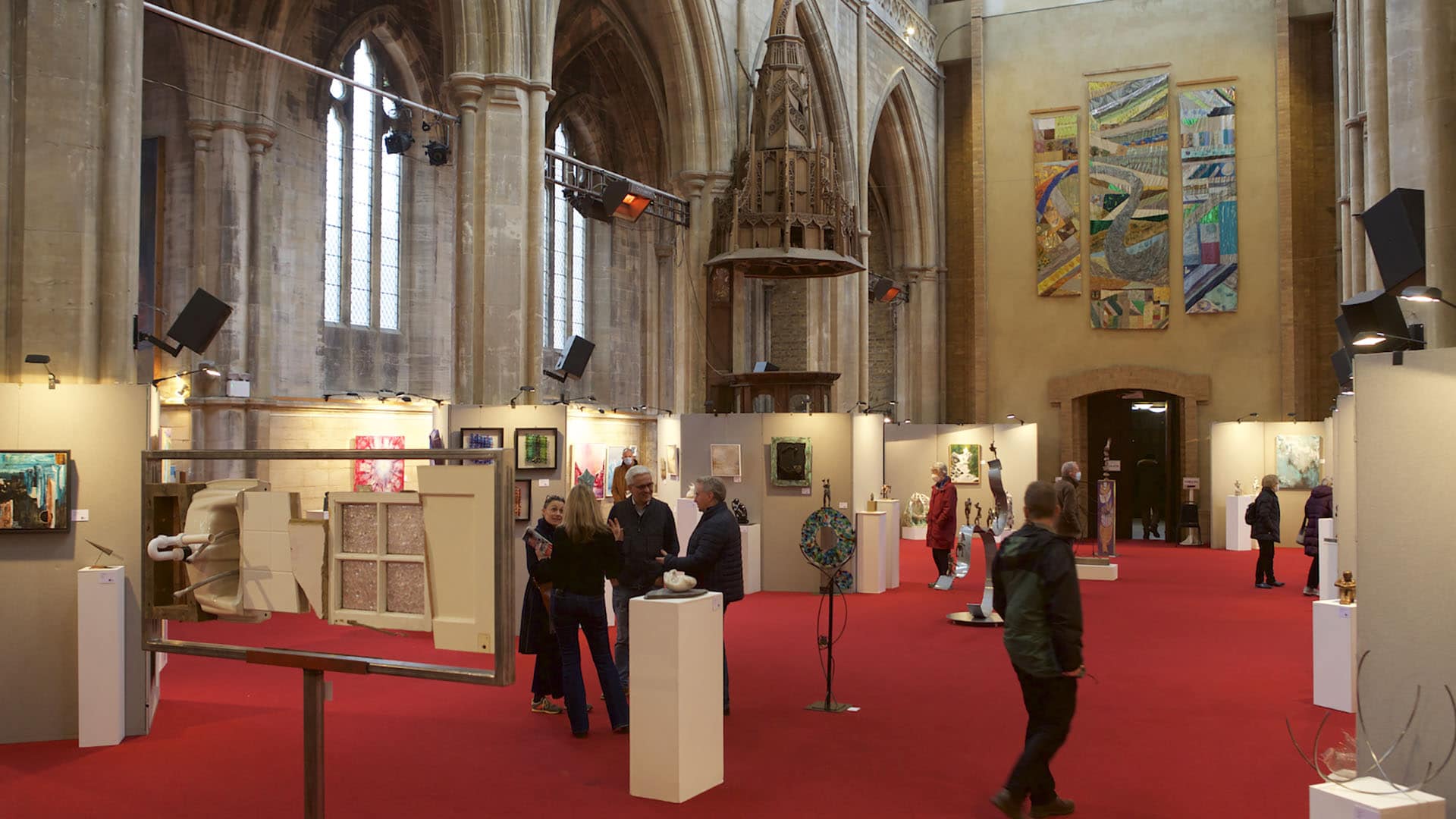 A photograph of people walking round a Surrey Sculpture Society exhibition at the Landmark Arts Centre.